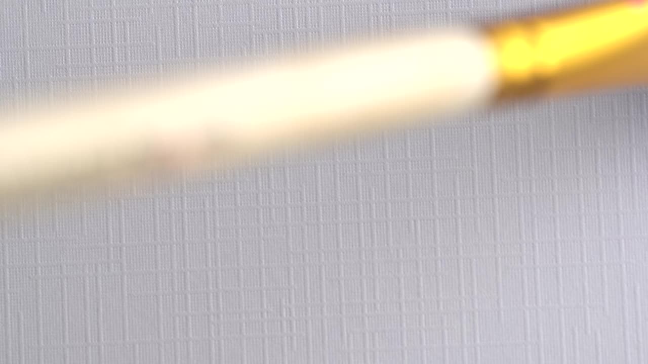 艺术家手持画笔绘制油画的特写。在画布上画薰衣草线。艺术家用紫色丙烯酸颜料作画