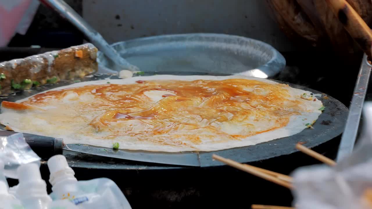 传统的煎饼被烤熟后包裹在街头小吃中。快餐和烹饪的概念