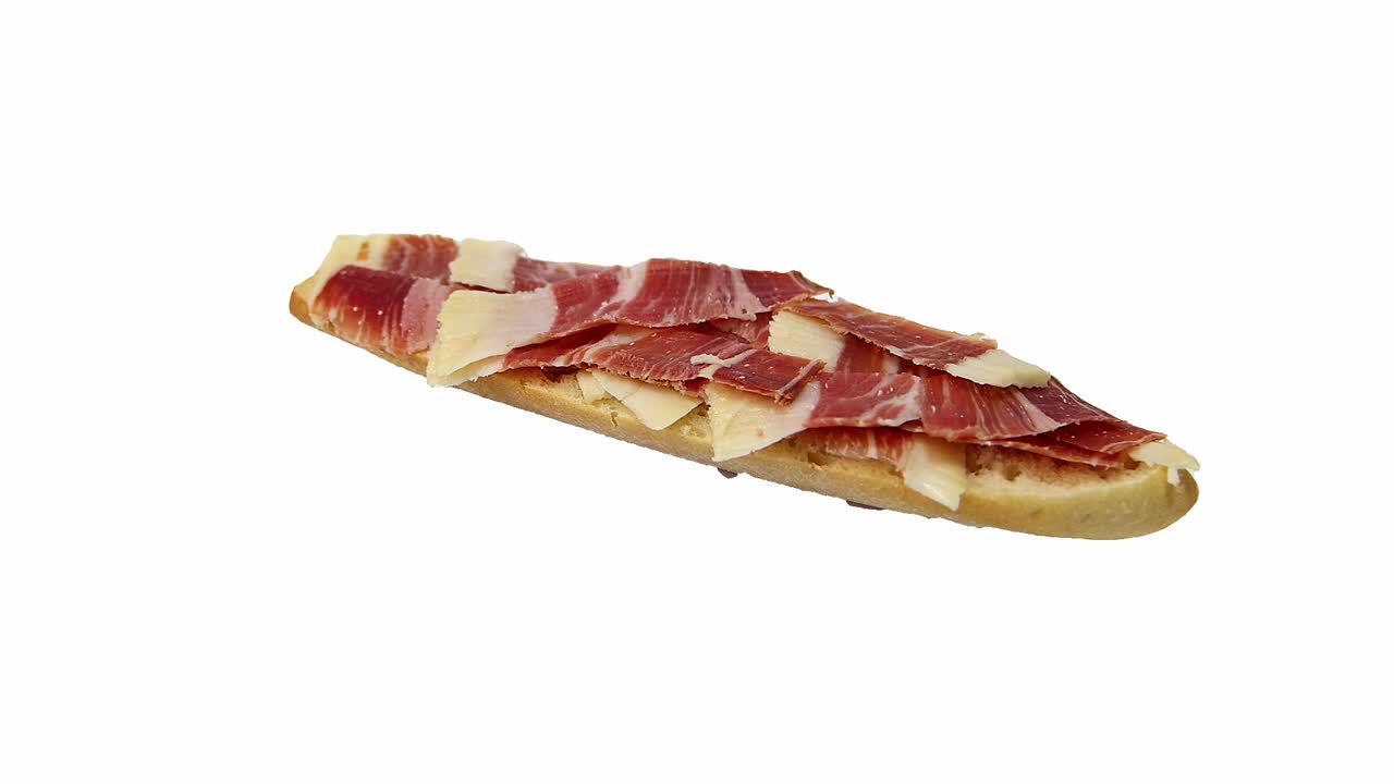 切片伊比利亚火腿(jamón serrano)在一片面包上，旋转，孤立在白色背景上。