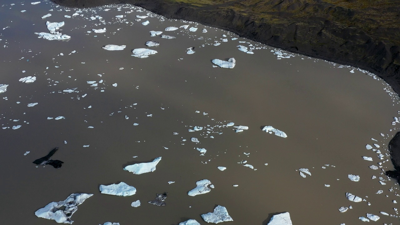 鸟瞰图:Vatnajökull冰川上的浮冰在冰岛海岸的黑色沙滩上漂浮在泻湖上