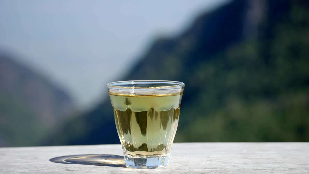 木托盘上的玻璃茶壶，手从茶壶里倒茶