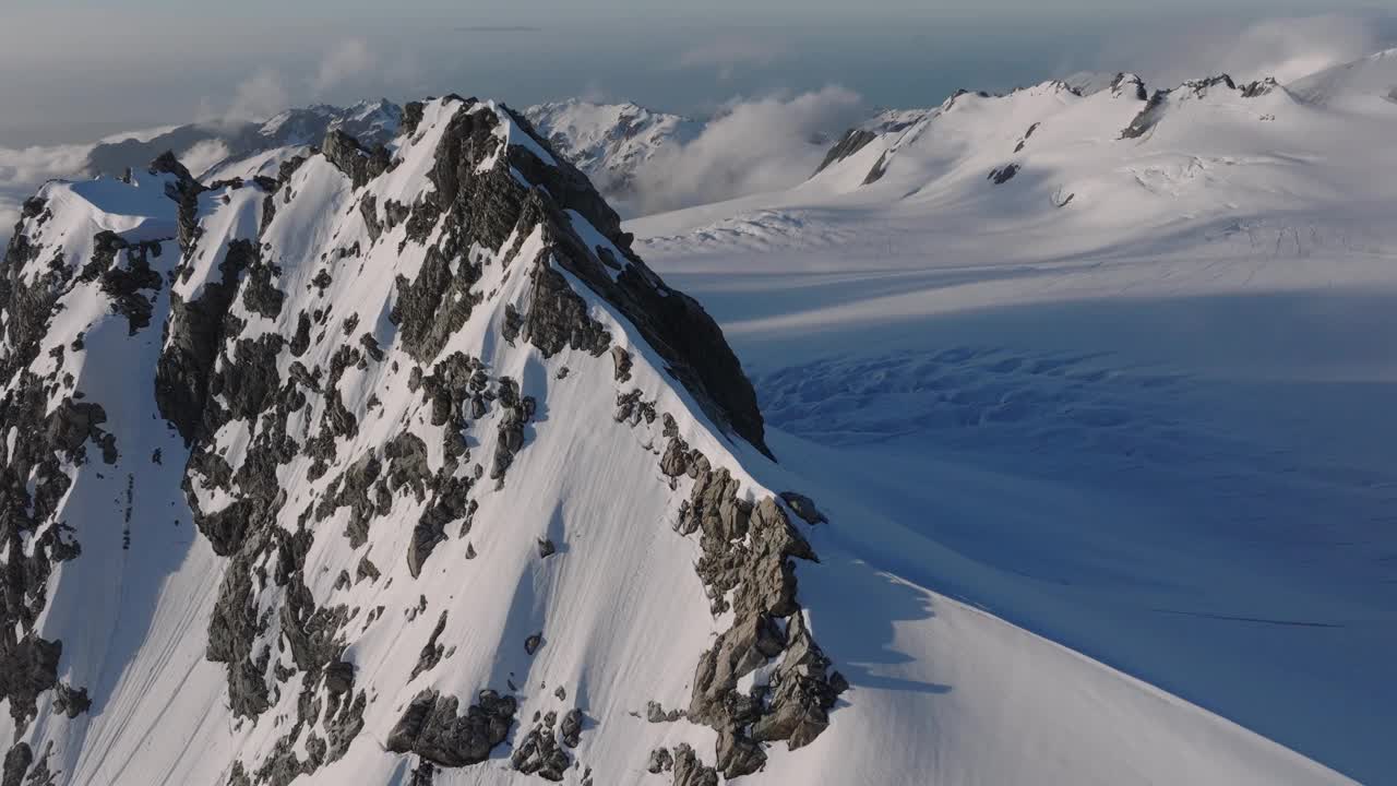 冰川和雪山在遥远的大自然的野生地带。壮丽的地形在一个美丽的一天，因为太阳落在这个北极冰冻的世界。巨大的裂缝将大地一分为二。无人机。