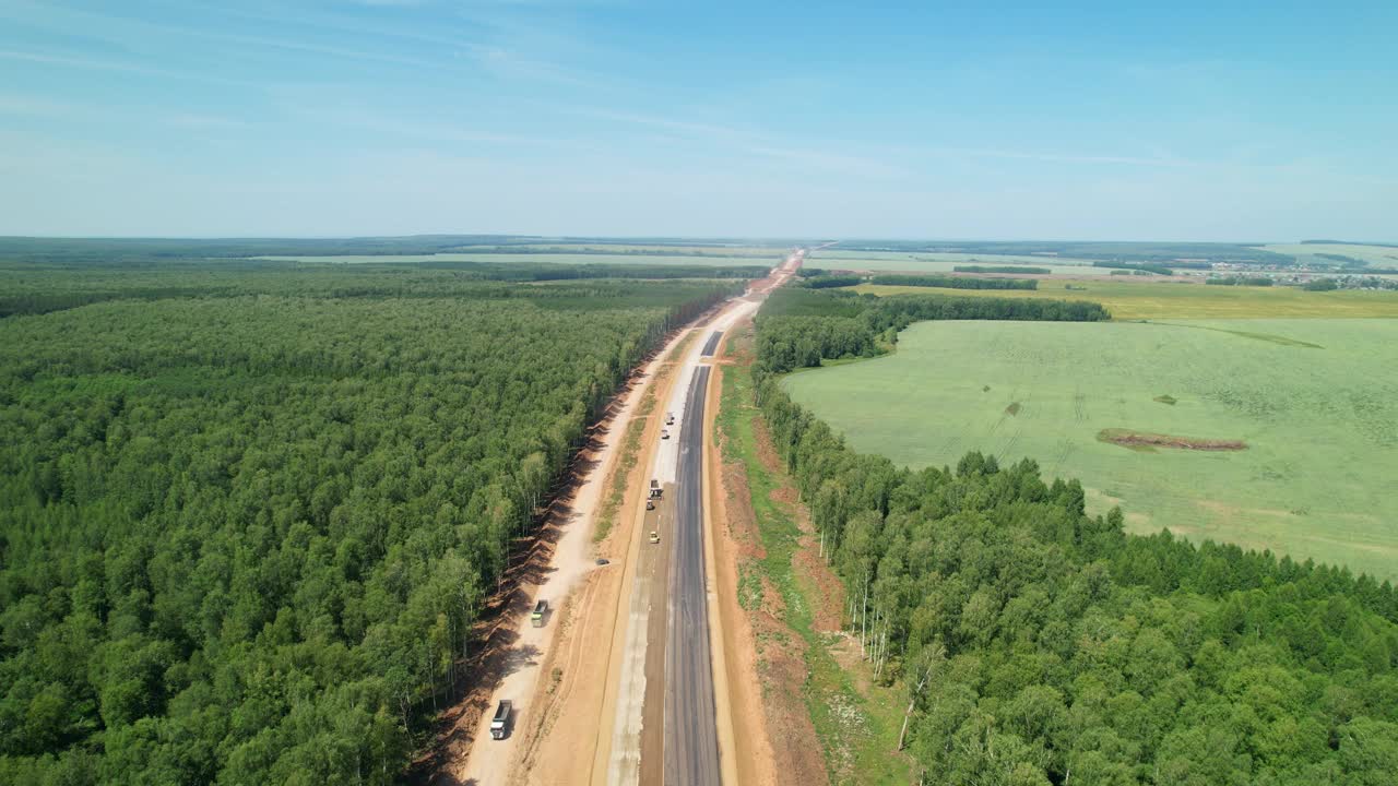 新建高速公路的鸟瞰图。为了修路而砍伐森林。这条在建的路一直延伸到远处。