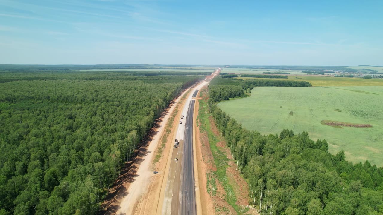 詳情圖-新建高速公路的鳥瞰圖。為了修路而砍伐森林。這條在建的路一直延伸到遠處。