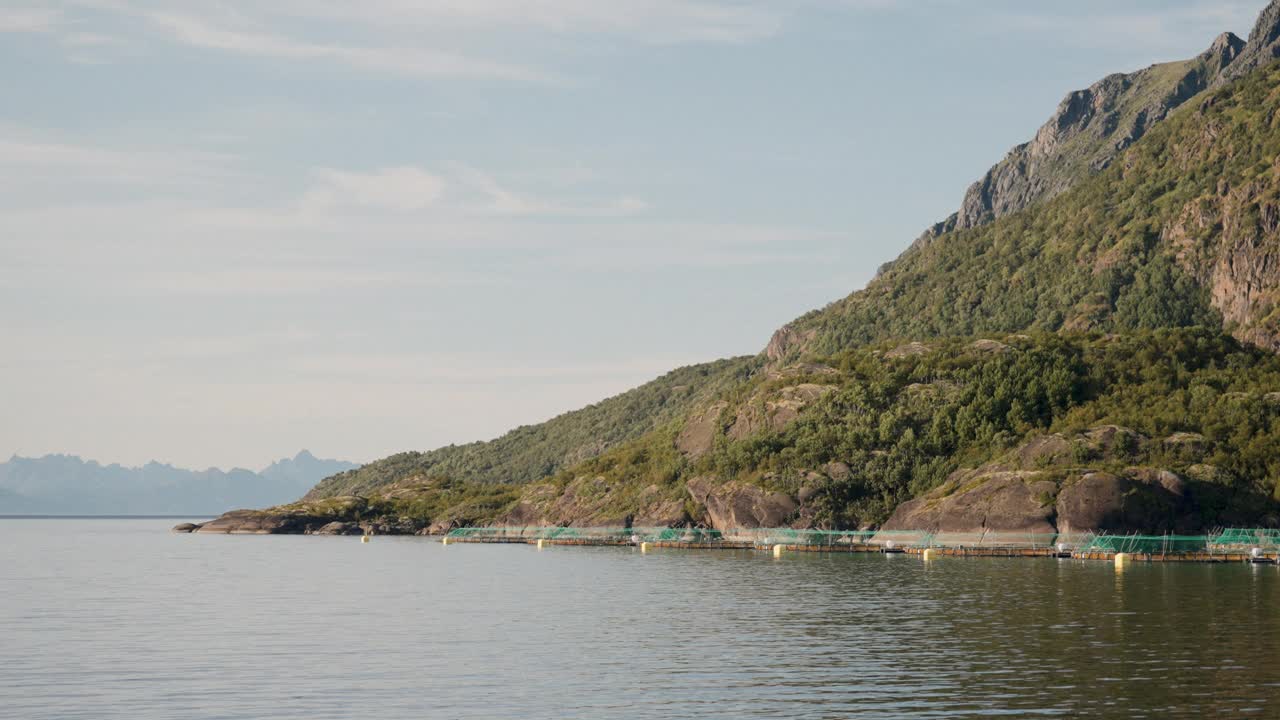 身后有雄伟山峰的水产养殖池