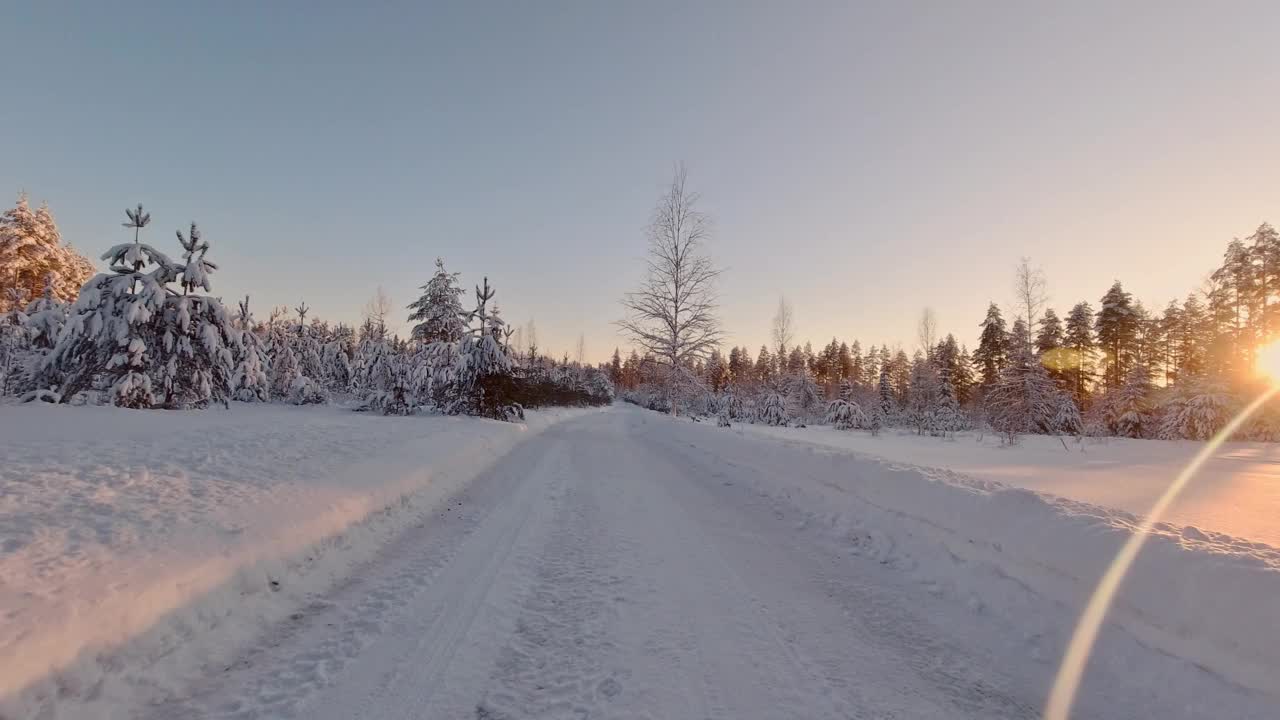 风景优美的POV驾驶在冰雪覆盖的冬季森林芬兰阳光景观