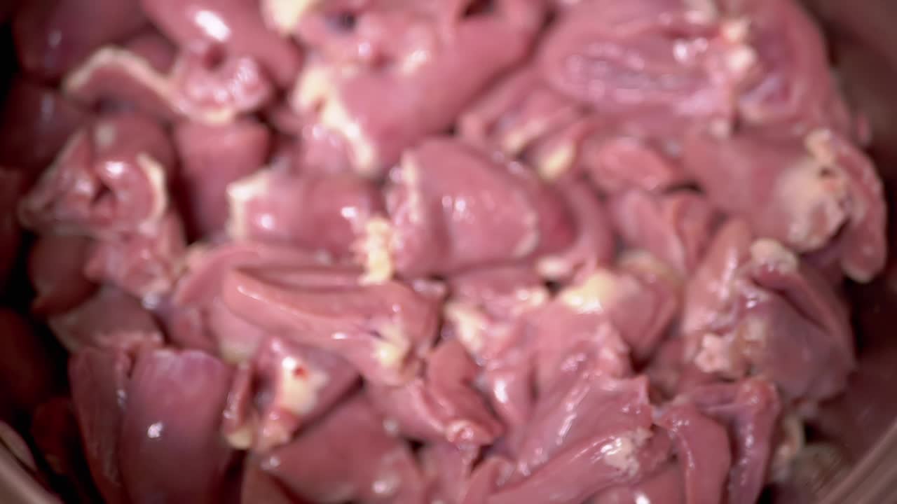 女性手里拿着新鲜的生的去皮的鸡心。慢动作