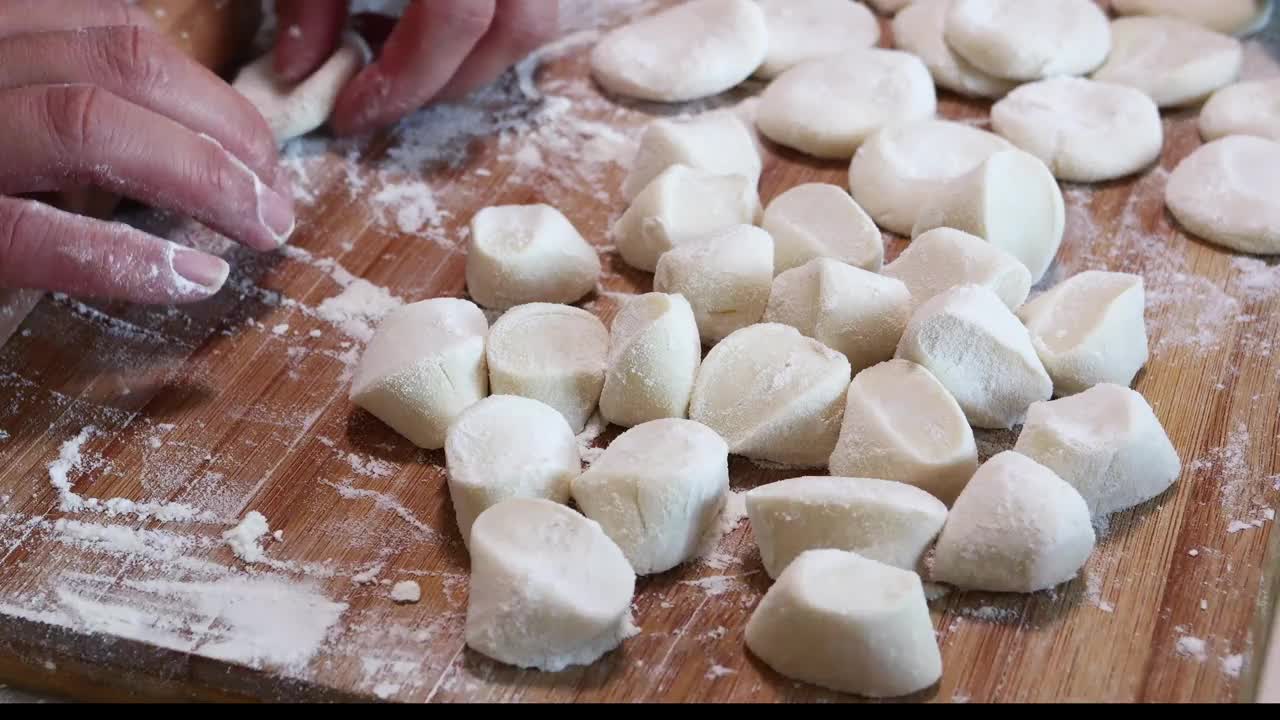 制作传统的中国饺子，在木板上擀出饺子皮