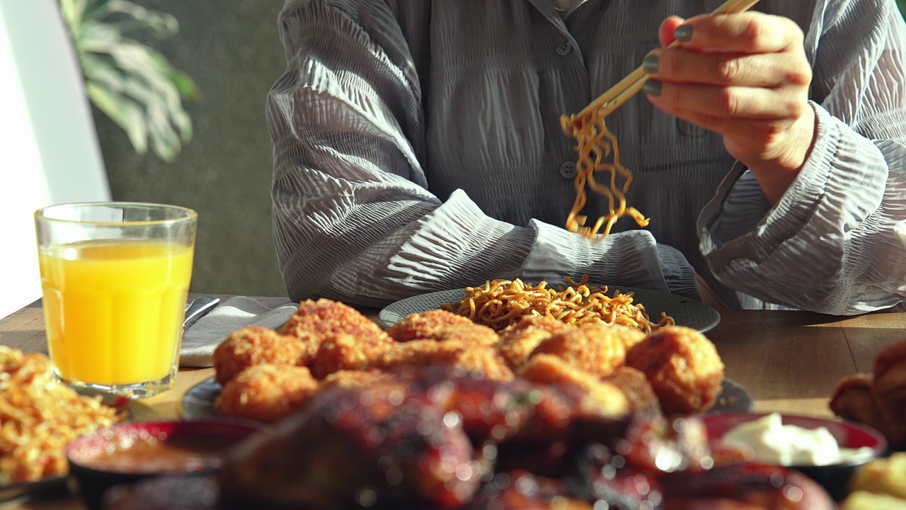 餐桌上的新鲜亚洲美食特写。以东方产品为原料的亚洲烹饪配方概念。女人喜欢吃面包奶酪和炒面