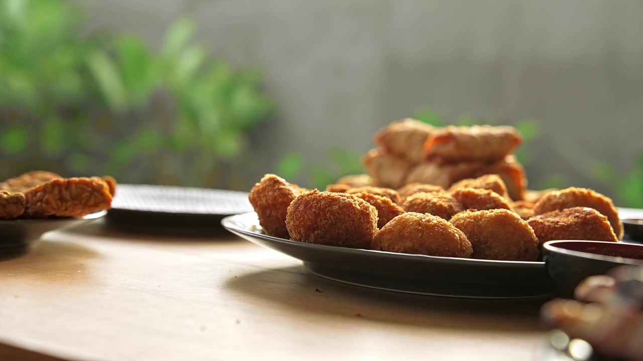 餐桌上的新鲜亚洲美食特写。东方产品烹饪的亚洲烹饪概念。在奶酪球或面包屑鸡肉中放入炒面