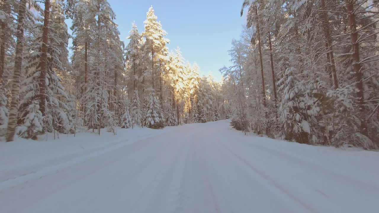 芬兰冬季森林中冰雪覆盖的道路使驾驶POV变得激动人心