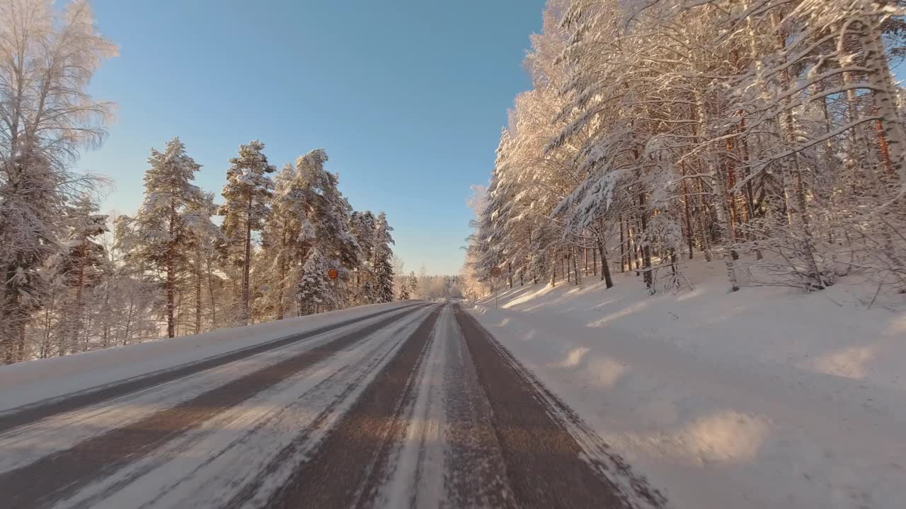 风景优美的冬季通勤在结冰的道路上POV驾驶通过森林公路芬兰