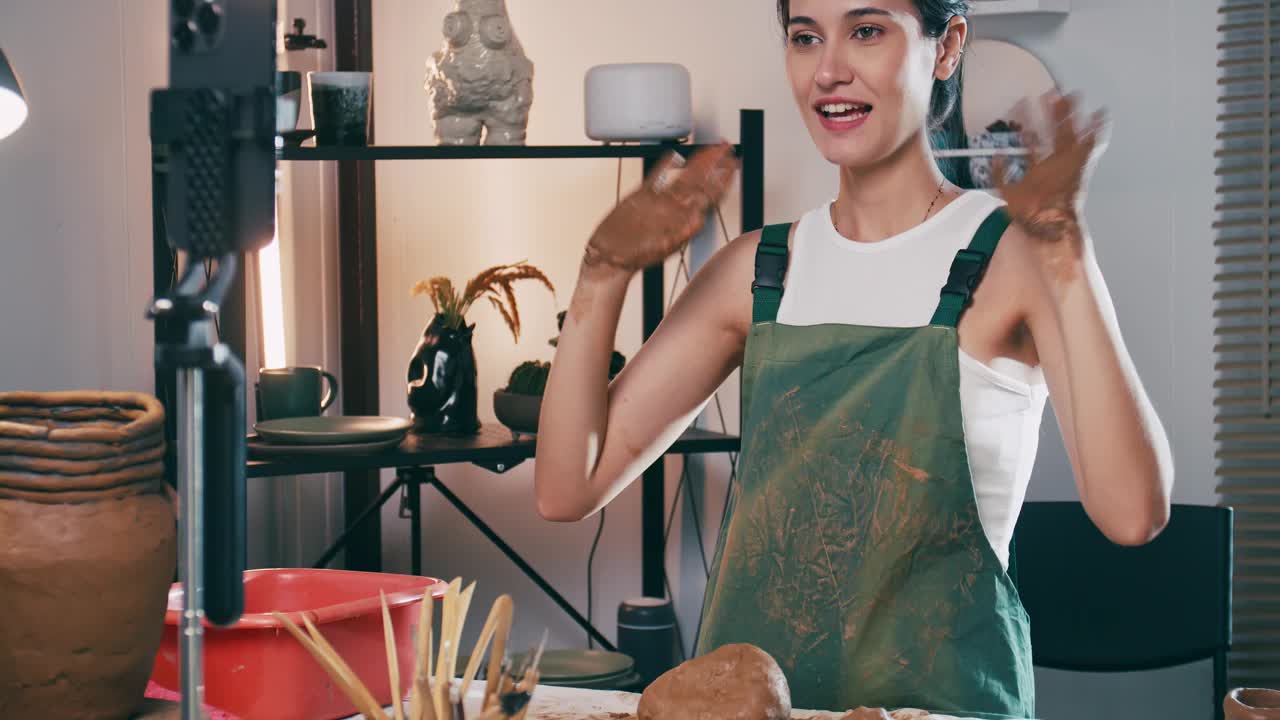 一名女陶艺家正在网上工作坊教授陶艺。一位亚洲妇女正在享受陶艺工作。