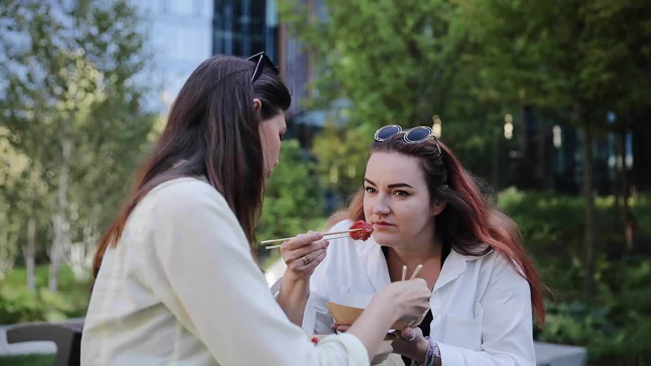 两名妇女在外面享用午餐，中国饺子