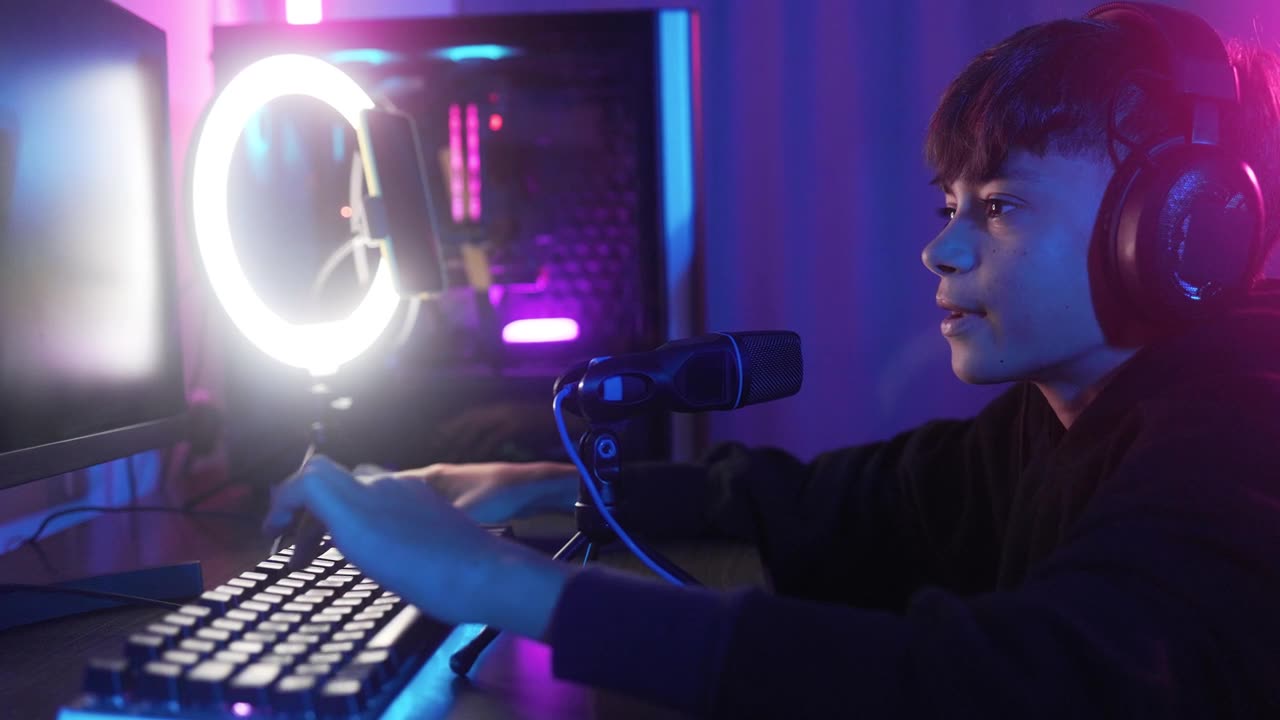 詳情圖-流玩家玩電子競技視頻游戲在線比賽。小男孩在游戲室內(nèi)與團(tuán)隊(duì)成員聊天