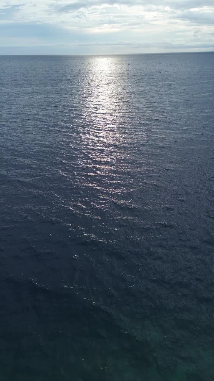 垂直无人机镜头的蓝海与阳光和蓝天