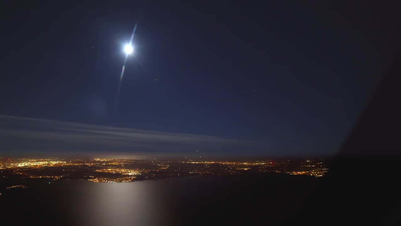 从飞机驾驶舱的夜景延时拍摄，地球上的灯光和上面的银河系