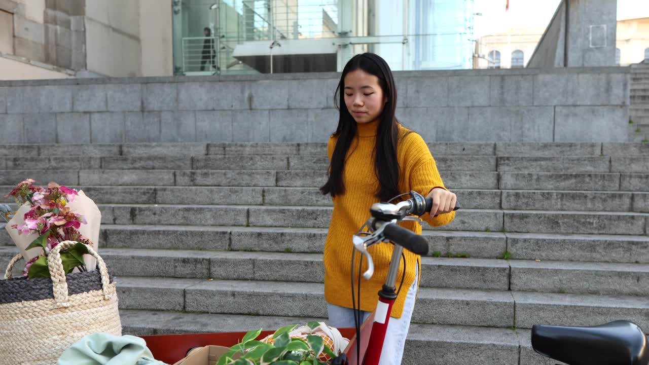 年轻的亚洲女子在骑自行车前用智能手机发送语音留言