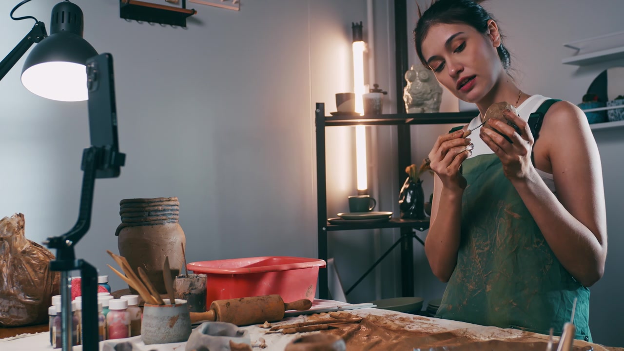 詳情圖-一名女陶藝家正在網(wǎng)上工作坊教授陶藝。一位亞洲婦女正在享受陶藝工作。