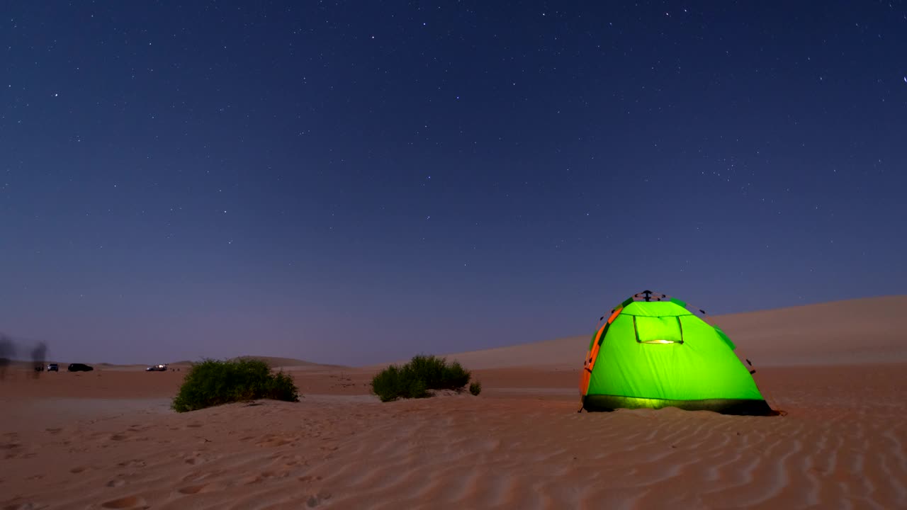 沙漠越野路上的露营帐篷上，星星在夜空中移动。