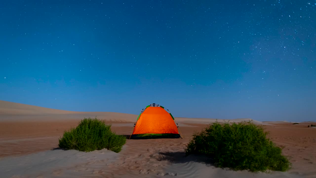 沙漠越野路上的露营帐篷上，星星在夜空中移动。