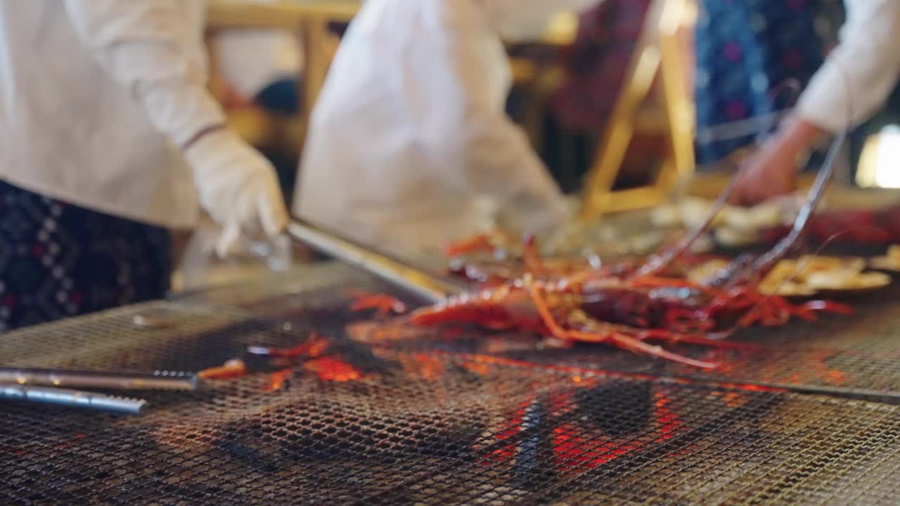 在鸟羽县的Osatsu海边小屋，Ama潜水员正在烤日本龙虾