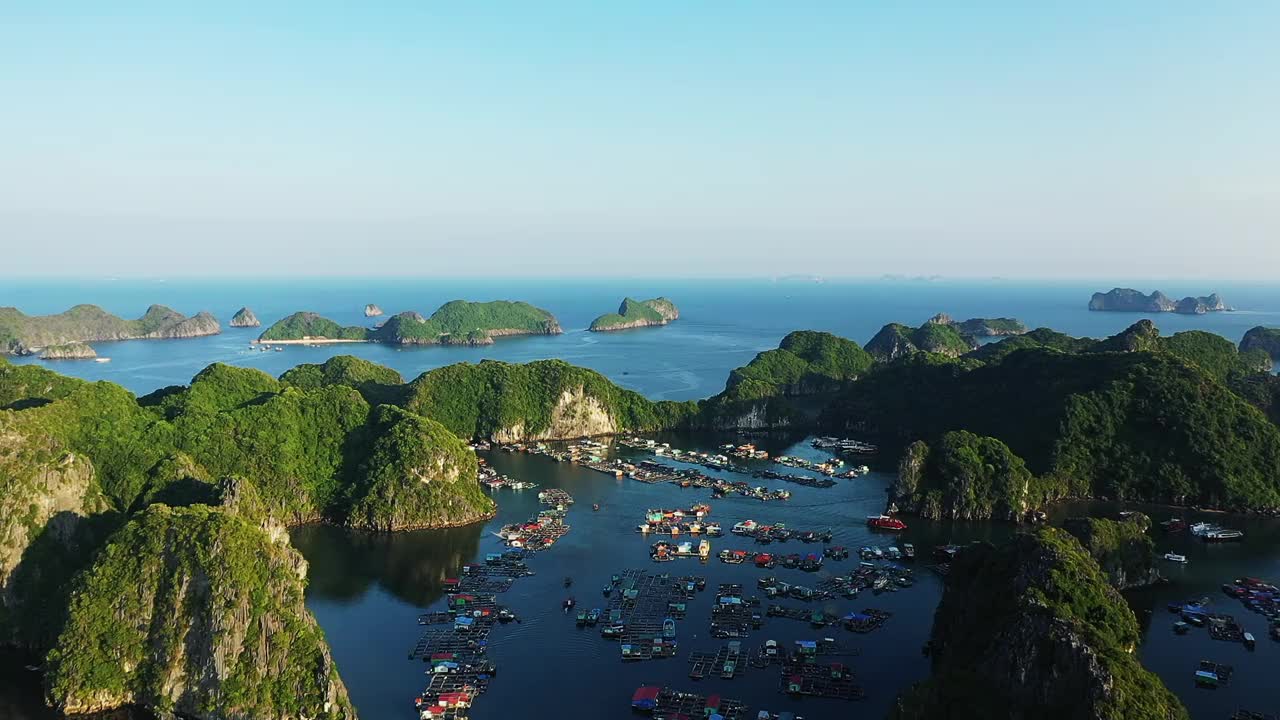 漂浮的村庄在美丽的喀斯特悬崖下龙湾，亚洲，越南北部，朝向海防，兰河在一个阳光明媚的夏天。