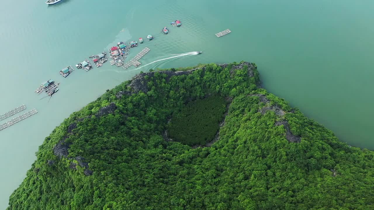 漂浮的村庄在绿色喀斯特悬崖下龙湾，亚洲，越南北部朝向海防，兰河在一个阳光明媚的夏天。