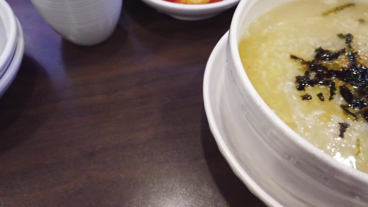 韩式热米粥，上面有烤芝麻和干海藻