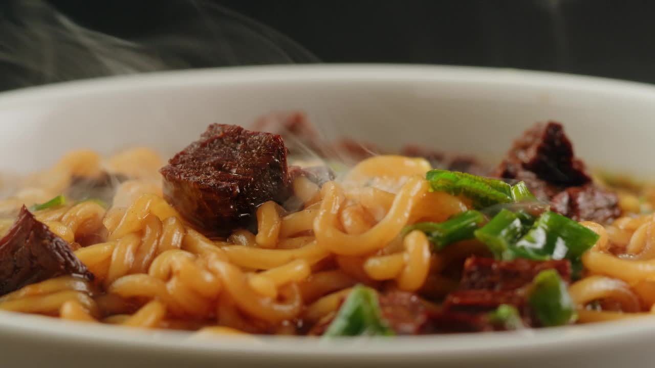 亚洲快餐面条配豆肉，香菜特写。把筷子掉在面条汤里。方便面，即方便面，是一种由预先煮熟并干燥的面条和调味粉和调味油组成的食品