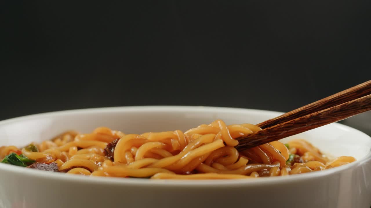 亚洲快餐面条配豆肉，香菜特写。在沸水中加入香料煮方便面。方便面，或方便面，是一种由预先煮熟和干燥的面条组成的食品，其中含有调味粉和