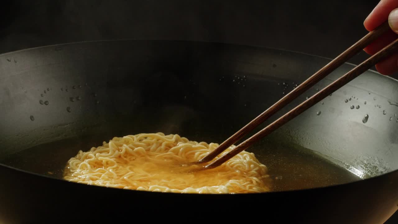 沸水煮泡面加香料特写。亚洲快餐。方便面，即方便面，是一种由预先煮熟并干燥的面条和调味粉和调味油组成的食品。烹饪或浸泡