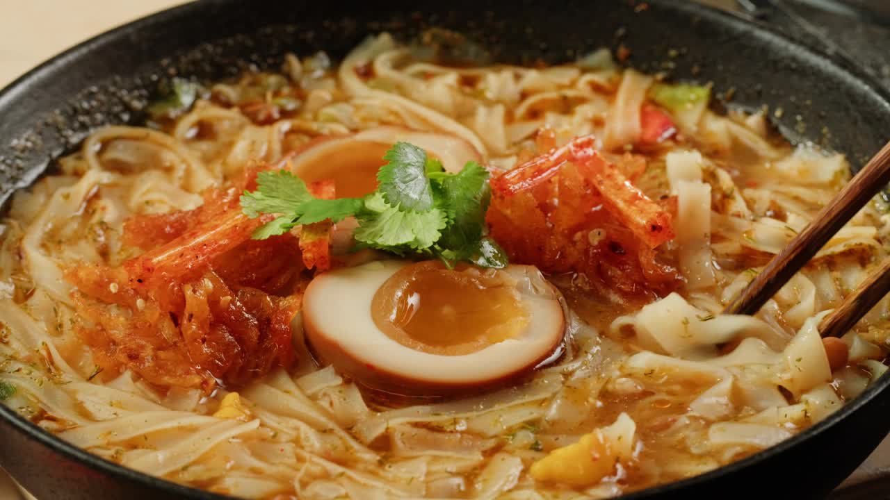 亚洲快餐面条用豆芽，欧芹和腌制或皮蛋特写。在沸水中加入香料煮方便面。方便面，或方便面，是一种由预先煮熟和干燥的面条组成的食品