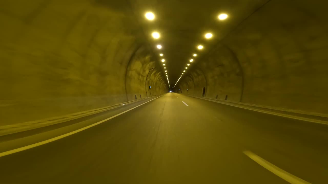 开车穿过隧道，视频捕捉到了黑暗中的汽车。行车经验，隧道内行车视角突出。专心驾驶，汽车在高速公路隧道中穿行