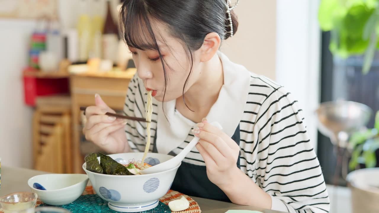 详情图-日本妇女在餐馆，吃拉面和食物的午餐或晚餐。面、碗和一个饥饿的年轻人、顾客或女孩用筷子独自享受健康餐或传统美食