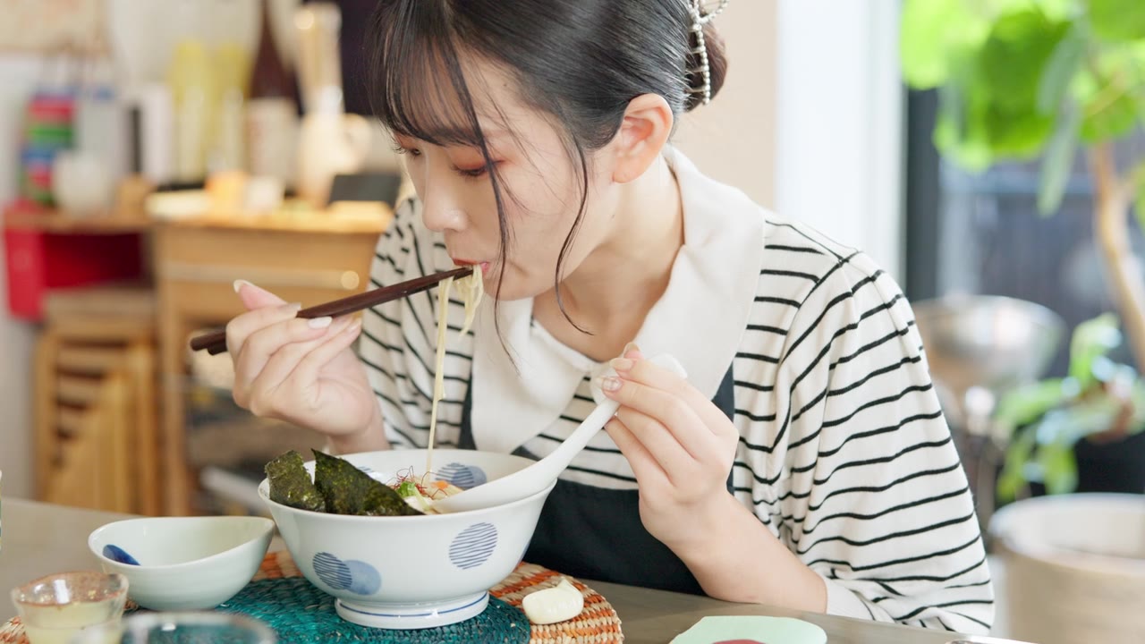 详情图-日本妇女在餐馆，吃拉面和食物的午餐或晚餐。面、碗和一个饥饿的年轻人、顾客或女孩用筷子独自享受健康餐或传统美食