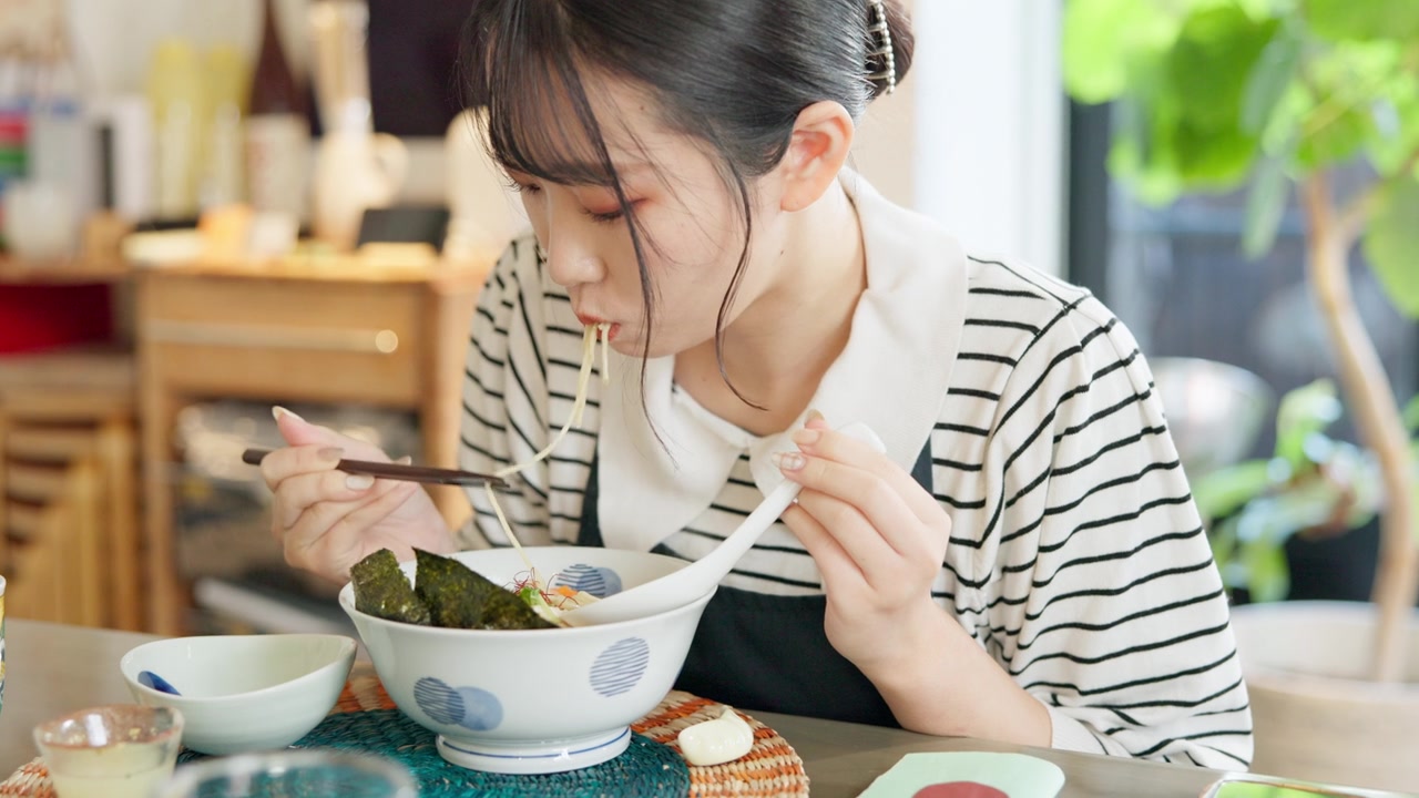 详情图-日本妇女在餐馆，吃拉面和食物的午餐或晚餐。面、碗和一个饥饿的年轻人、顾客或女孩用筷子独自享受健康餐或传统美食