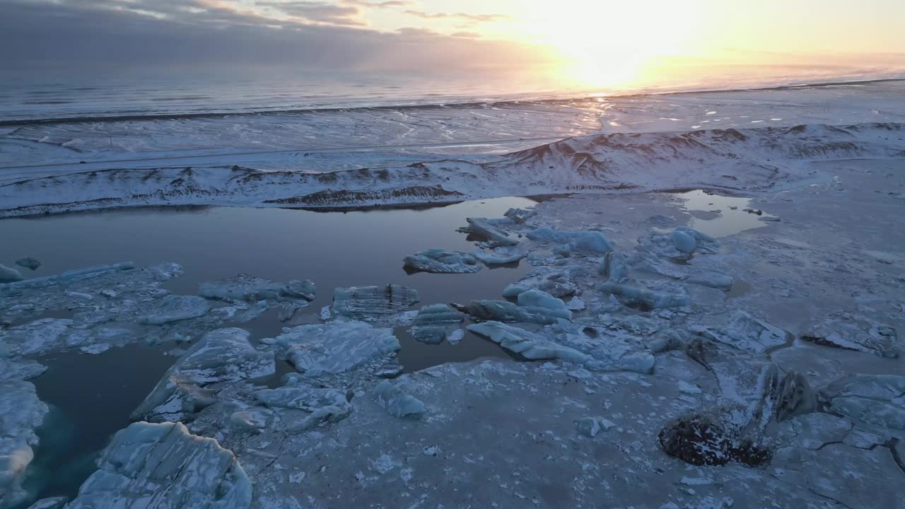 冰岛南部冰川泻湖上生动的日落，照亮了浮冰