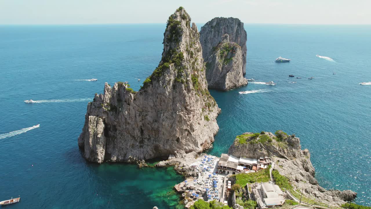 雄伟的海崖耸立在湛蓝海水的海湾之上。岩层的自然美和休闲船。意大利卡普里岛的Da Luigi ai Faraglioni海滩。