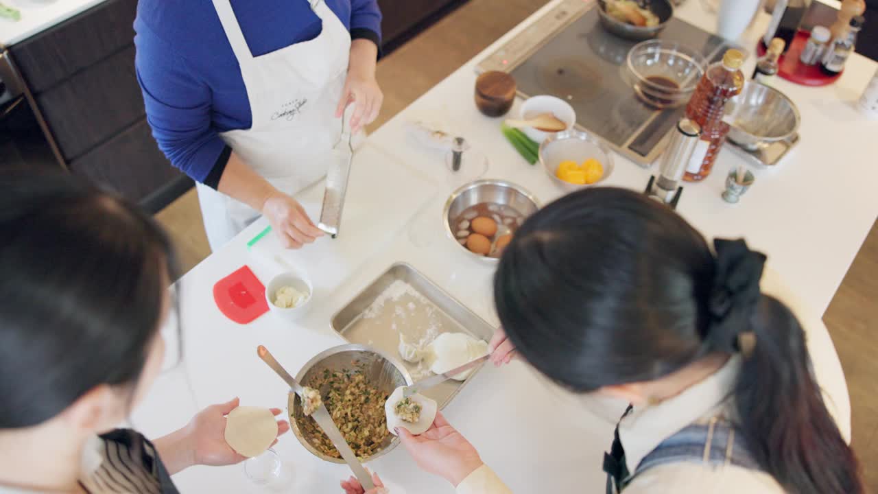 妇女，日本和饺子或烹饪准备教菜谱，传统餐或亚洲餐饮。女性在厨房里学习文化、饮食或营养的双手和顶视图