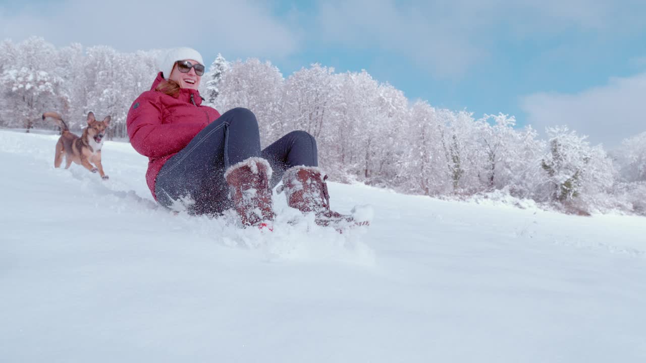 一个微笑的年轻女子在一只可爱的狗的陪伴下在雪地上滑雪