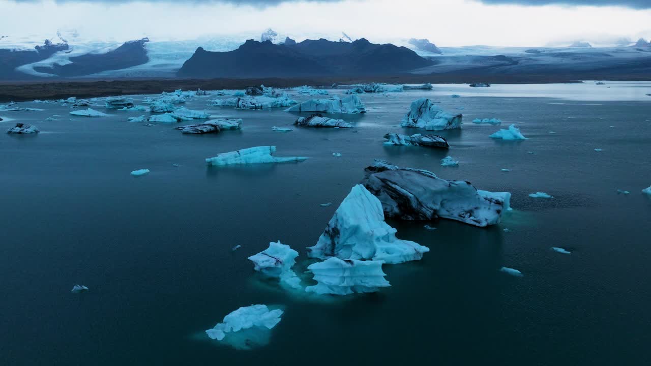 漂浮的冰山在Jökulsárlón冰川泻湖在冰岛日出-空中无人机拍摄