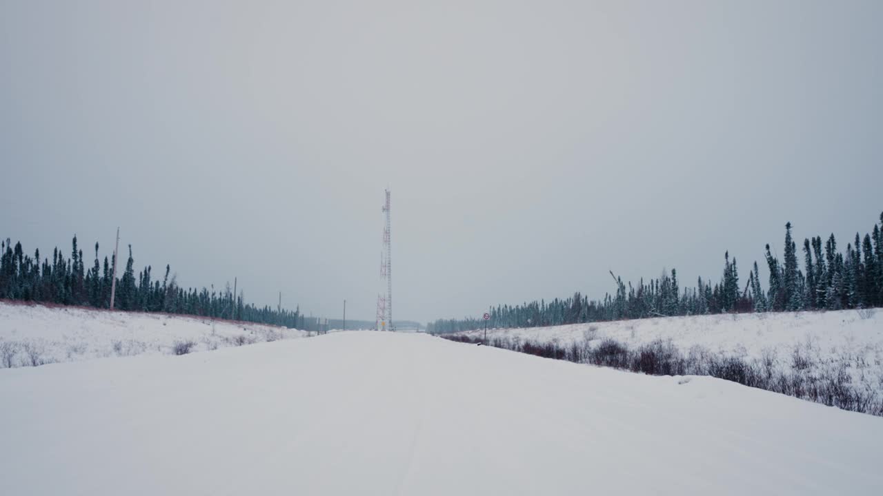 静止的4K远摄摄的电网无线电天线末端的冬季雪道之间的森林树木线