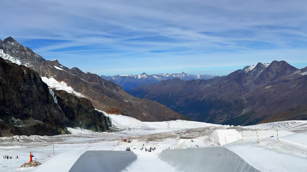 夏秋秋训练u型管滑雪板滑雪踏脚场地空中无人机飞行萨斯费萨斯塔尔滑雪胜地冰川阳光明媚美丽的蓝天高云雪冰盘向下揭示