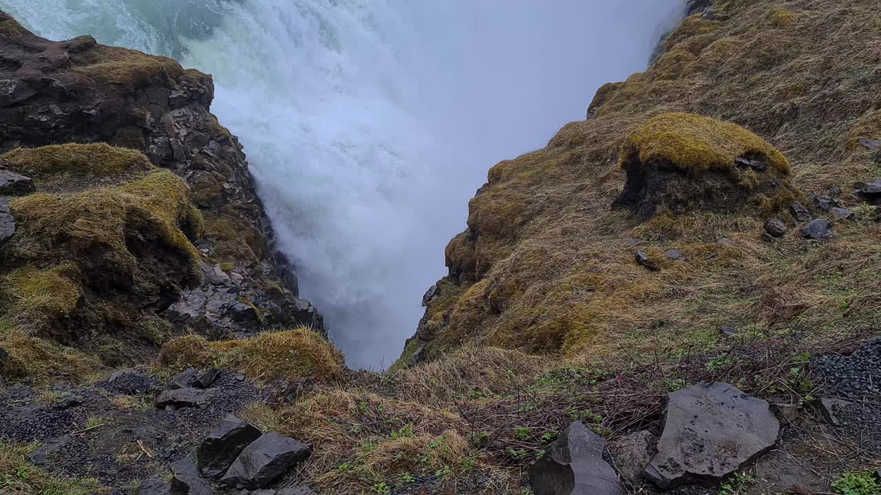 强大的瀑布在冰岛景观，冰川水流入深狭窄的峡谷