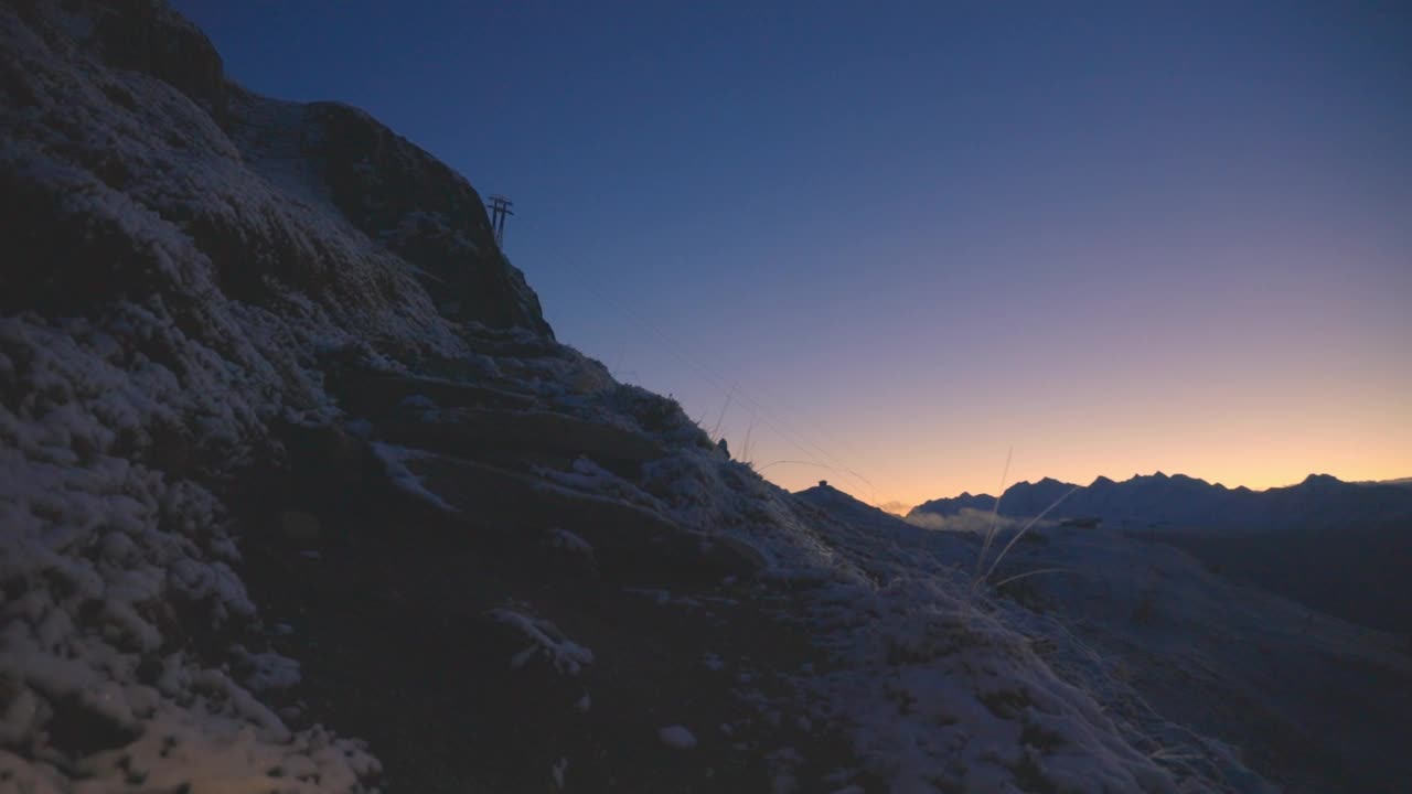 在瑞士阿尔卑斯山脉，阿莱奇冰川地区的黄昏时分，登山游客沿着山路徒步旅行