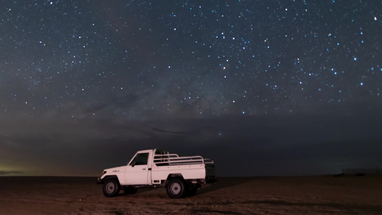 详情图-空旷的沙漠中骆驼农场营地上空夜空银河的流逝