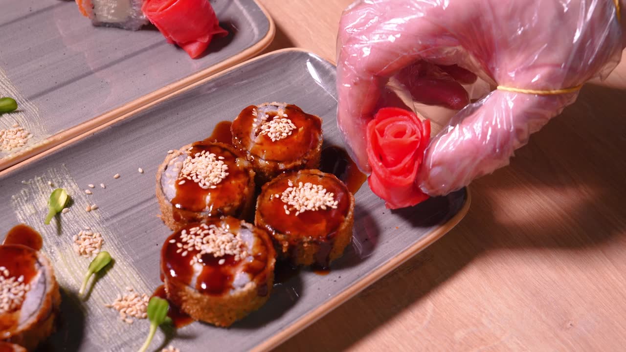 詳情圖-廚師的手將玫瑰姜片放在美味的壽司盤上
