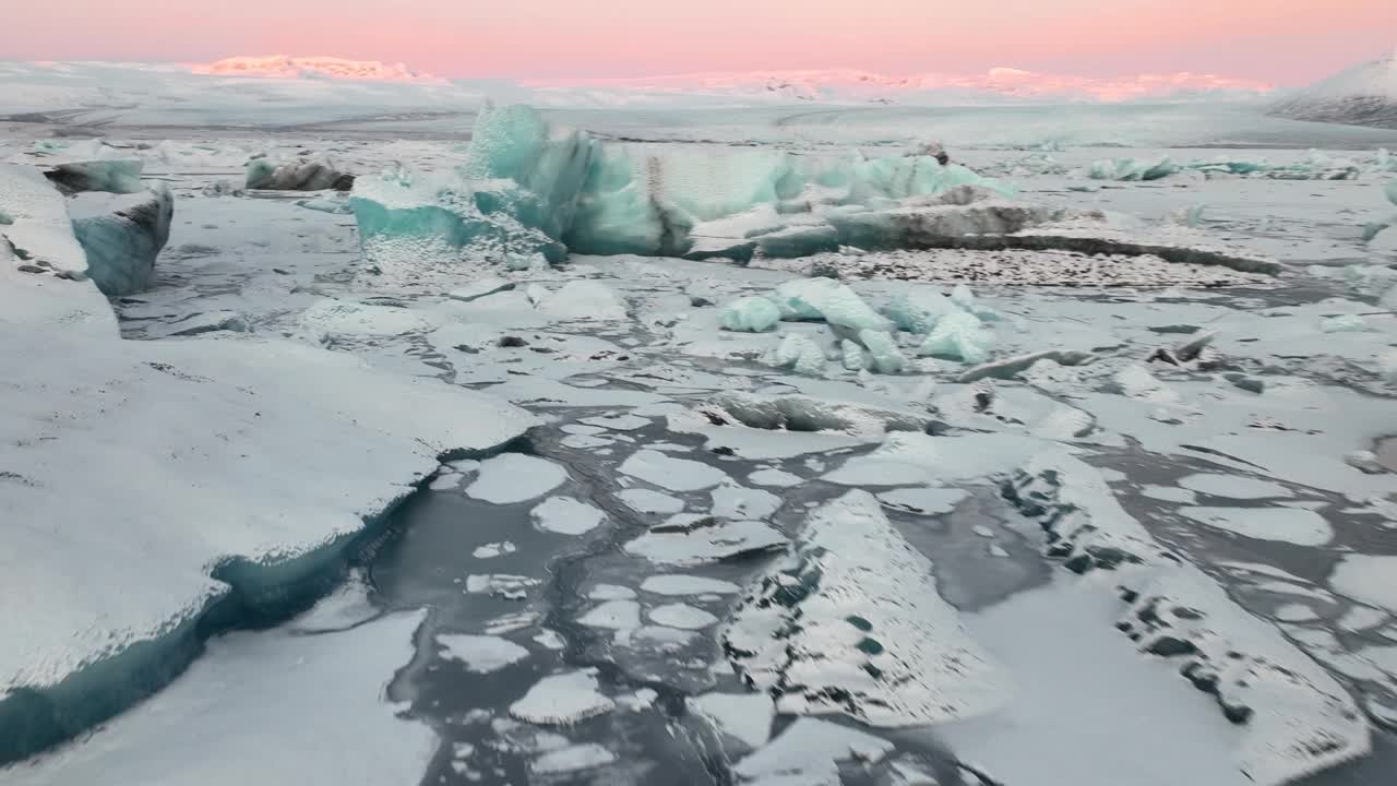 在冰岛南部日出时飞越Jokulsarlon冰川湖的冰山。-航拍