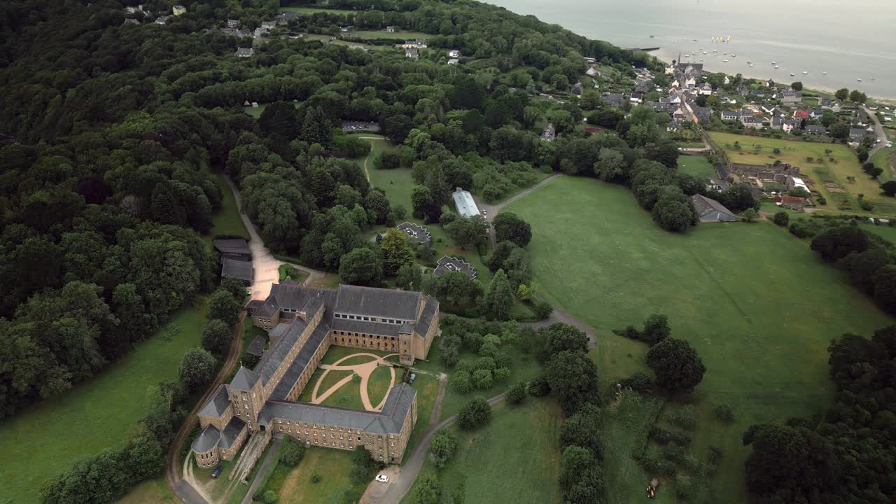 全景多丽鸟瞰图的大寺院建筑包围的树木上坡的一个村庄由一条河